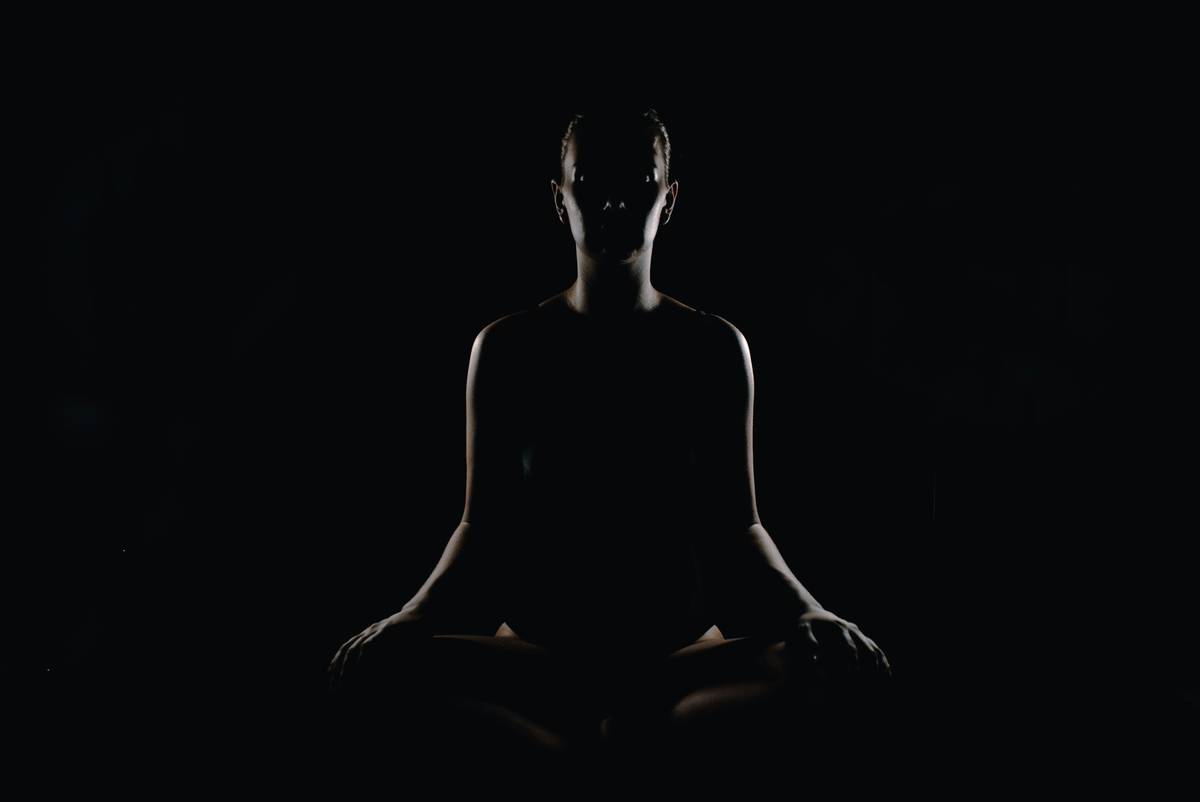 how to meditate for anxiety relief: person sitting calmly with eyes closed, hands resting on knees